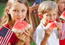 kids eating watermelon and holding American flags